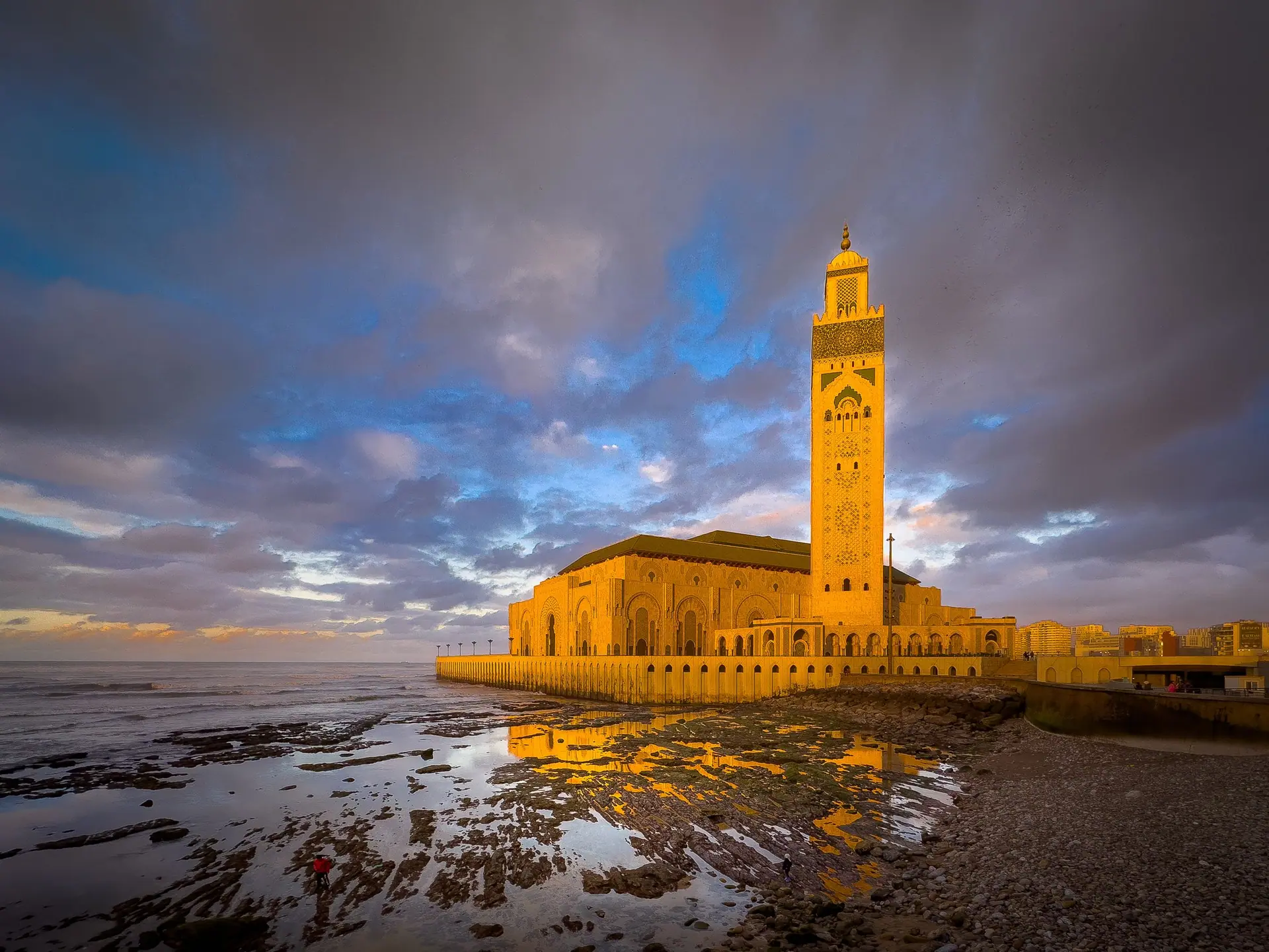Majestic Hassan II Mosque at sunset reflecting in Atlantic Ocean waters, Casablanca.