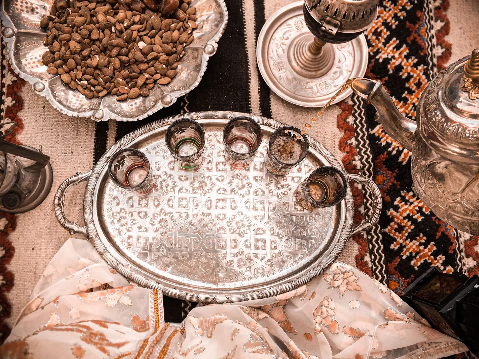 Elegant Moroccan tea setup on a decorative tray with almonds in Marrakesh, Morocco.
