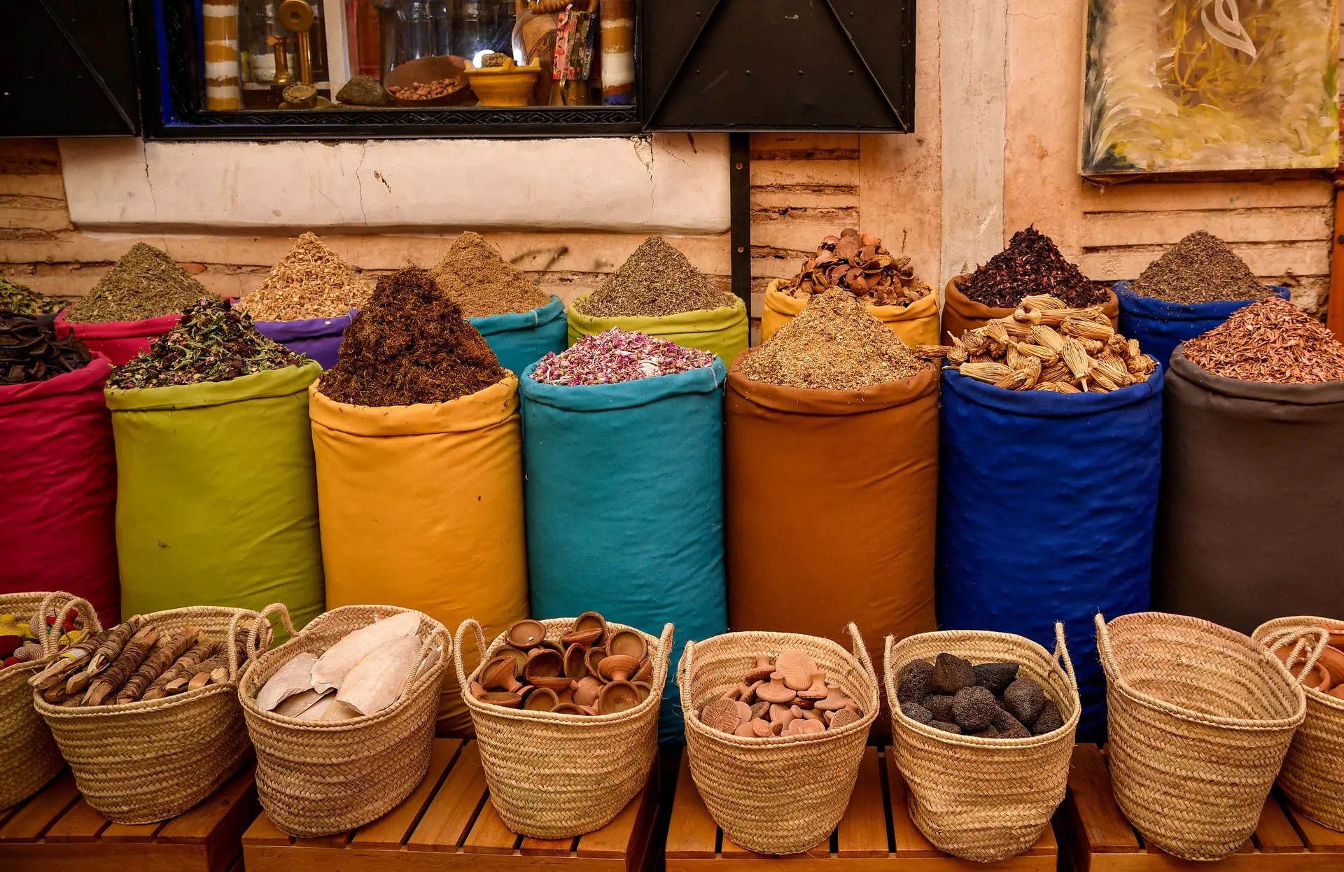 Colorful spice sacks in a Marrakesh souk depicting Moroccan culture.